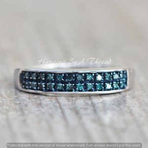 May include: A silver band ring with a double row of blue diamonds.