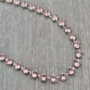 May include: A silver chain necklace with pink crystal beads.