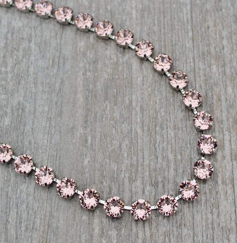 May include: A silver chain necklace with pink crystal beads.