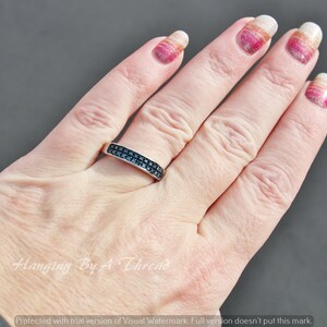 May include: A silver band ring with a double row of black cubic zirconia stones.
