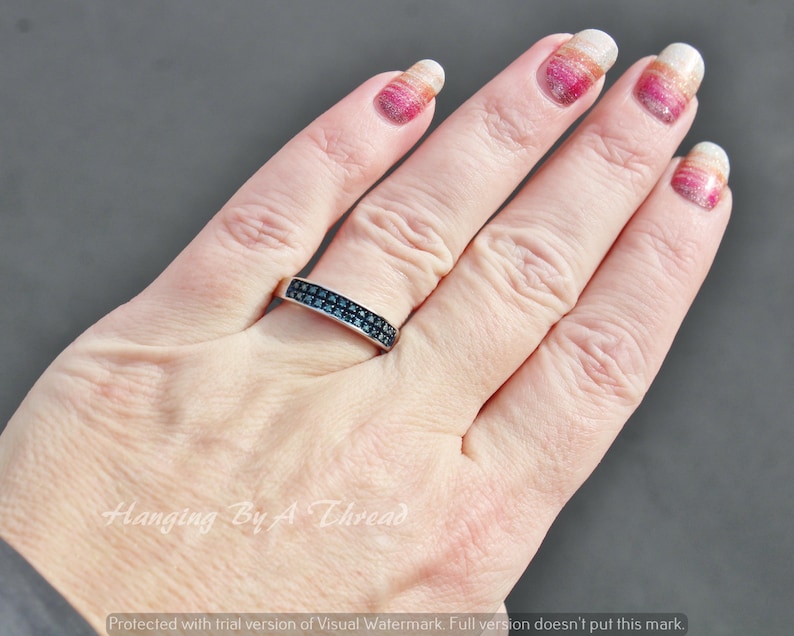 May include: A silver band ring with a double row of black cubic zirconia stones.