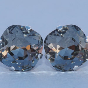 Puede incluir: Un par de pendientes de plata con piedras de cristal gris oscuro. Las piedras son facetadas y tienen forma cuadrada.