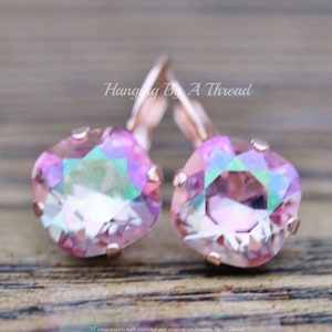 May include: Rose gold earrings with pink iridescent square crystals. Hanging By A Thread.