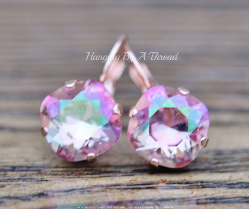 May include: Rose gold earrings with pink iridescent square crystals. Hanging By A Thread.