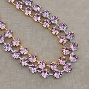 May include: A double strand of pink crystal beads with gold and silver accents. The beads are round and have a faceted finish. The necklace is perfect for adding a touch of sparkle to any outfit.