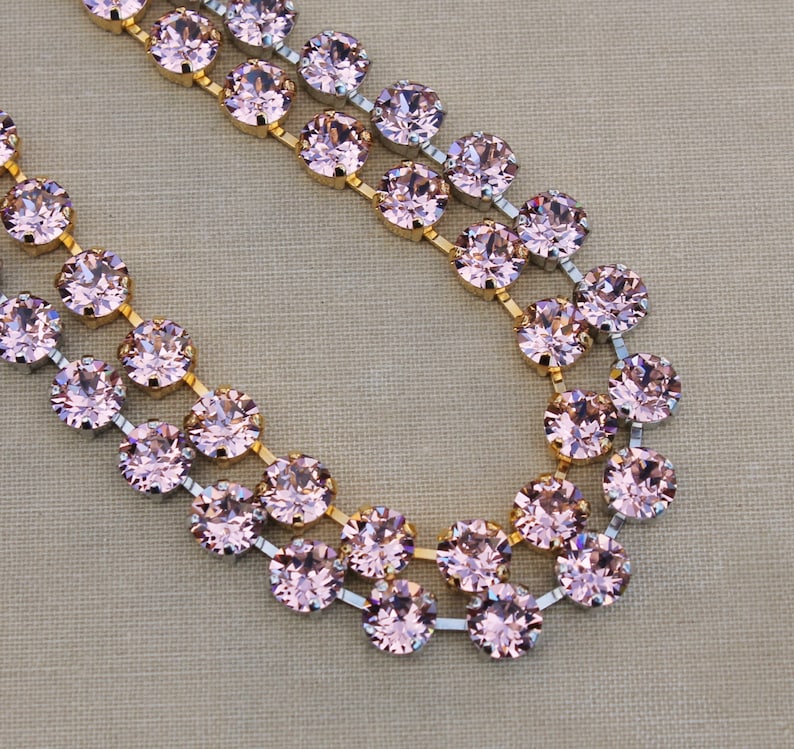 May include: A double strand of pink crystal beads with gold and silver accents. The beads are round and have a faceted finish. The necklace is perfect for adding a touch of sparkle to any outfit.