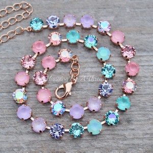 May include: A rose gold chain necklace with pastel pink, lavender, and turquoise crystal beads. The necklace has a lobster clasp closure.