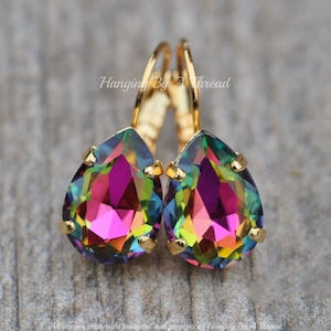 Puede incluir: Pendientes de gota de oro con cristales de arcoíris iridiscentes. Los pendientes tienen un cierre de gancho.