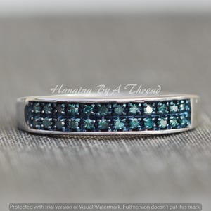 May include: A silver band ring with two rows of small, blue diamonds.