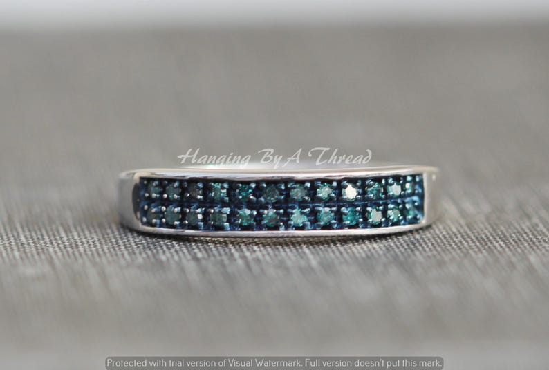 May include: A silver band ring with two rows of small, blue diamonds.