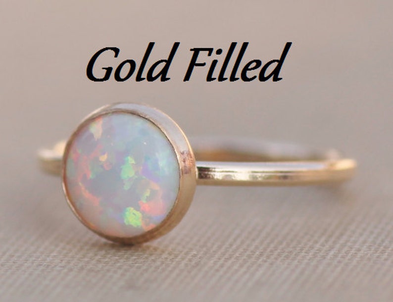 May include: A gold filled ring with a white opal gemstone. The ring is simple and elegant, perfect for everyday wear.
