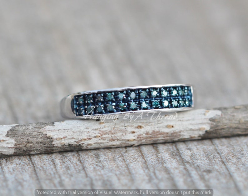 May include: A silver band ring with a double row of blue diamonds.