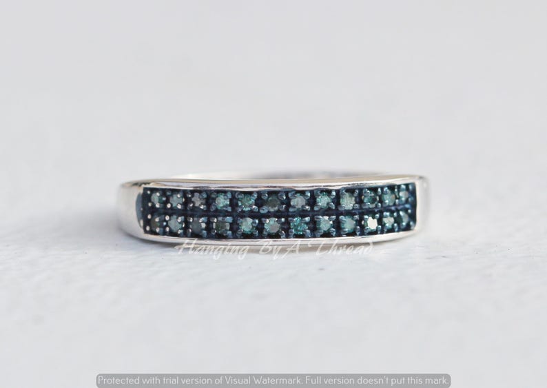 May include: A silver band ring with two rows of small, dark blue diamonds.