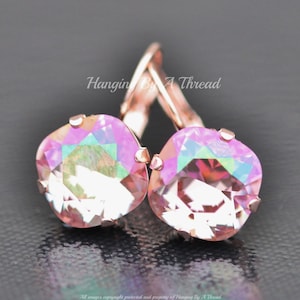 May include: Rose gold earrings with iridescent pink square crystals. The earrings have a lever back closure.