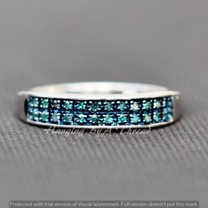 May include: A silver band ring with two rows of blue diamonds.