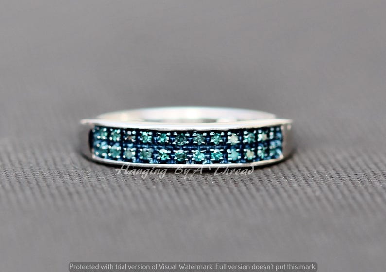 May include: A silver band ring with two rows of blue diamonds.