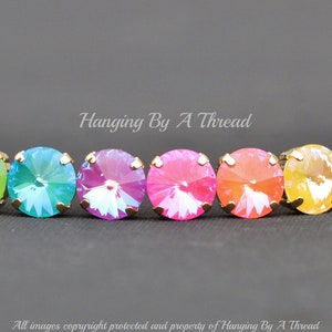 May include: Rainbow crystal bracelet with gold accents. The bracelet features a row of round, iridescent crystals in a rainbow color sequence.