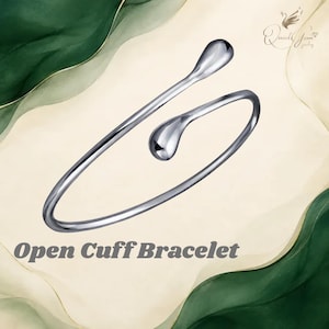 May include: A silver-toned open cuff bracelet featuring two smooth, teardrop-shaped ends. The piece has a polished, reflective finish and a minimalist, circular design. The text "Open Cuff Bracelet" is printed below the jewelry item.