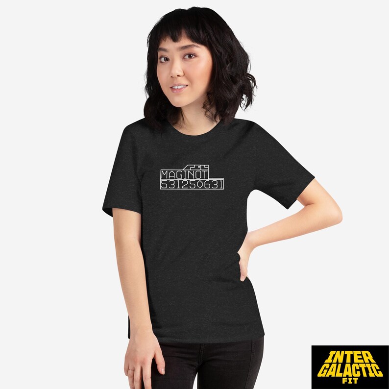Peut inclure: T-shirt gris fonc&eacute; avec le texte blanc "MAGINOT 531250631". Le t-shirt est &agrave; col rond et &agrave; manches courtes. Le logo Inter Galactic Fit est visible en bas &agrave; droite.