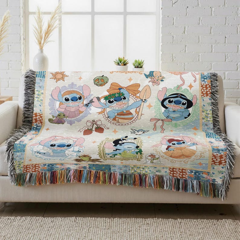 a cozy and colorful throw blanket with various cartoon characters from the Disney movie "Stitch". The blanket is placed on a white couch, and there are some decorative elements such as a potted plant and a vase in the background.