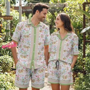 May include: Matching pajama sets with a light blue background and a repeating pattern of cartoon characters, cherries, and bows. The sets include a short-sleeved button-up shirt and shorts with green trim. The Acid Hollow logo is visible in the corner.