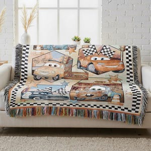 A colorful throw blanket with a Cars-themed design, featuring various race cars and racing elements.