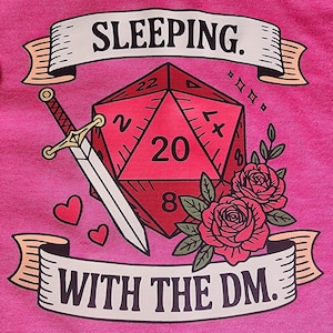 Puede incluir: Camiseta rosa con un dado rojo de veinte caras, una espada, rosas y el texto "SLEEPING. WITH THE DM." El diseño incluye corazones y pancartas decorativas. Un diseño divertido y único para jugadores.