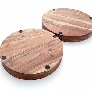 Puede incluir: Dos tablas redondas de madera para servir con un acabado de vetas naturales. Cada tabla tiene un borde grueso y redondeado y peque&ntilde;os pies de goma negros. Las tablas son de madera marr&oacute;n c&aacute;lido y est&aacute;n sobre un fondo blanco.