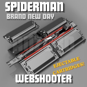 May include: A Spiderman Brand New Day webshooter device featuring a metallic grey finish with a central red accent line and multiple rectangular ejectable cartridges. The text SPIDERMAN BRAND NEW DAY and EJECTABLE CARTRIDGES WEBSHOOTER is visible.