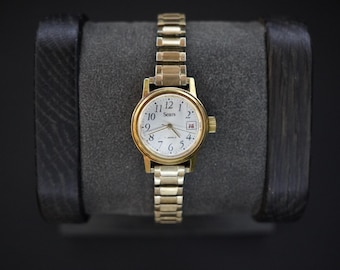 Reloj mecánico automático vintage Sears en tono dorado para hombre, de cuerda automática, en funcionamiento.