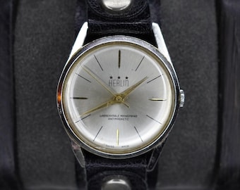Reloj de pulsera mecánico Herlin vintage de fabricación suiza con esfera plateada y protección antimagnética.