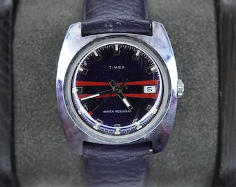 Reloj Timex vintage de 1973 para hombre, de cuerda manual, con fecha, esfera azul y franja roja.