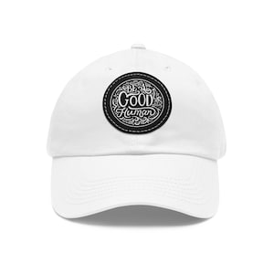 May include: White baseball cap with a black embroidered patch that says "Be a Good Human" in a decorative font.