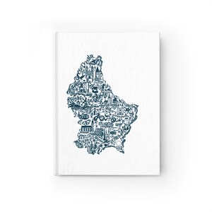 May include: A white hardcover notebook featuring a dark blue ink illustration of the map of Luxembourg. The map is filled with intricate line drawings of landmarks, local flora, fauna, and city names including Wiltz, Redange, Diekirch, and Remich.