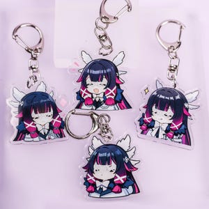 May include: Five anime-style acrylic keychains featuring a character with dark hair, pink accents, and white wings. Each keychain has a silver clasp. The character is wearing a white bow tie and a blue and white outfit.