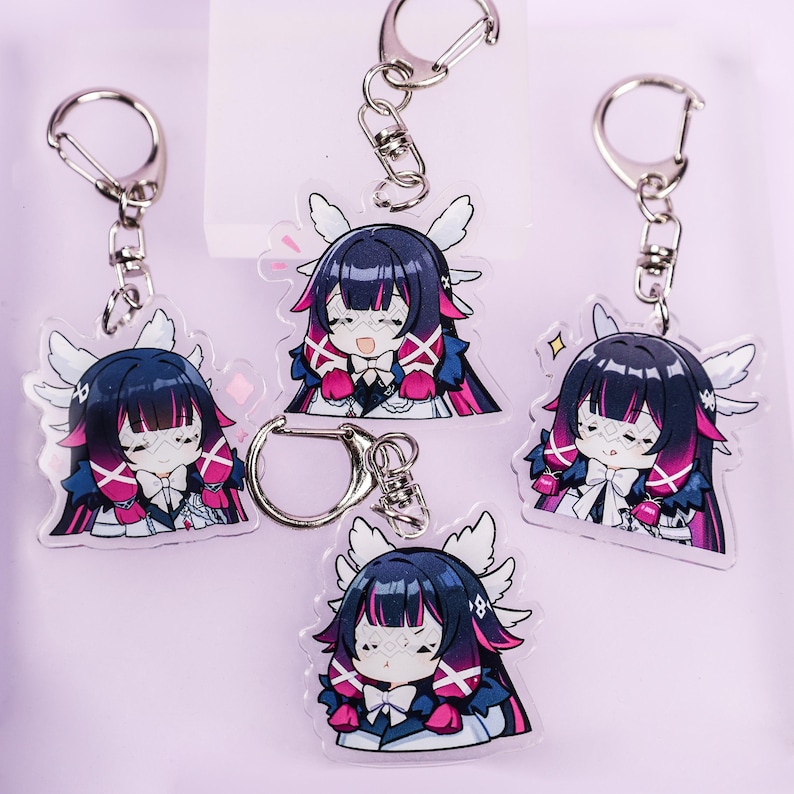 May include: Five anime-style acrylic keychains featuring a character with dark hair, pink accents, and white wings. Each keychain has a silver clasp. The character is wearing a white bow tie and a blue and white outfit.