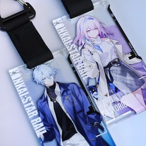 Könnte beinhalten: Zwei transparente Ausweishalter aus Acryl mit Charakterkunst im Anime-Stil. Einer zeigt einen Charakter mit blauen Haaren und einer blauen Jacke, der andere einen Charakter mit lila Haaren und einem weißen Mantel. Beide haben schwarze Schlüsselbänder und den Text "HONKAI: STAR RAIL".