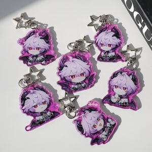 May include: A collection of seven anime-style keychains. Each keychain features a character with white hair, red eyes, and a dark outfit, set against a pink background. The keychains have star-shaped clasps.