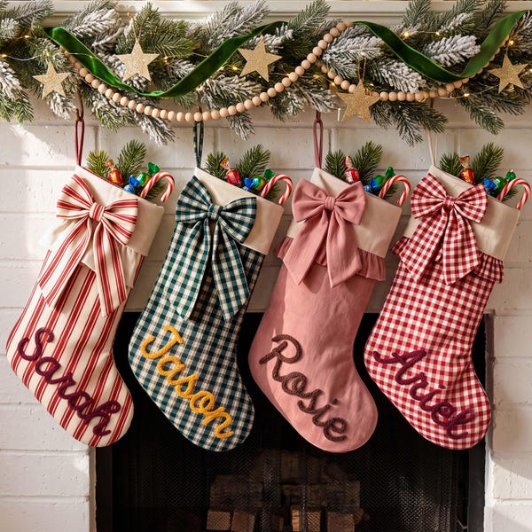May include: Four personalized Christmas stockings hanging in a row. The first is red and white striped with the name Sarah, the second is green and white plaid with Jason, the third is solid pink with Rosie, and the fourth is red and white gingham with Ariel.