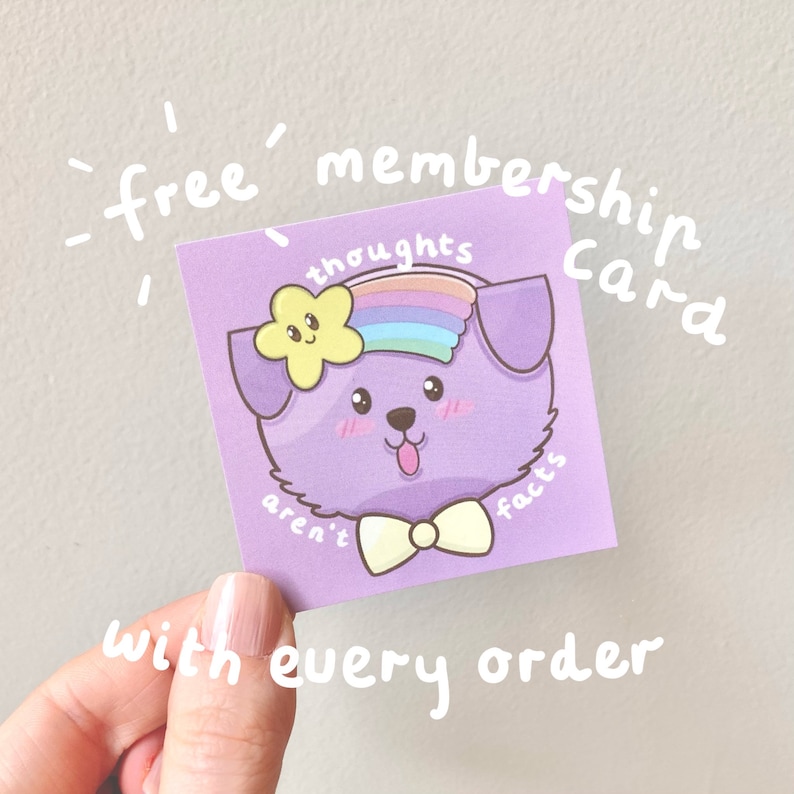 Pu&ograve; includere: Carta viola con un cane di cartone animato che indossa una fascia arcobaleno e un fiore giallo. La carta dice "carta di iscrizione gratuita" e "i pensieri non sono fatti".