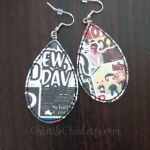 May include: Pair of teardrop-shaped earrings. One earring features a black and white design with the text "NEW DAV". The other earring displays a collage of images. Both earrings have a black stitched border and silver-colored ear wires. The Etsy shop name "OhLittleChild.etsy.com" is visible.