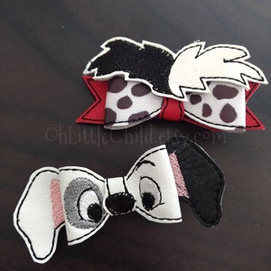 May include: Two handmade hair bows. The top bow features a black and white spotted pattern with a red accent. The bottom bow is designed to resemble a Dalmatian dog's face, with white, black, and pink details. The bows are set against a dark background.