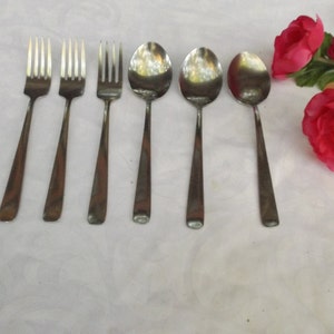 May include: A set of six silver utensils, including three forks and three spoons. The utensils are arranged in a row on a white surface.