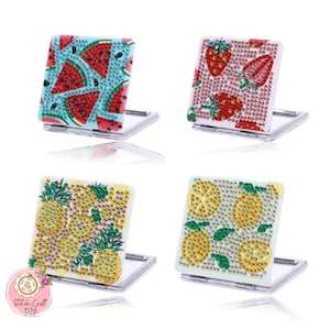 Peut inclure: Quatre miroirs compacts carrés et pliables avec des motifs de fruits. L'un présente des tranches de pastèque sur fond bleu. Un autre a des fraises sur fond rose. Le troisième a des ananas et le quatrième des tranches de citron.