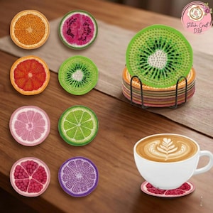 May include: A selection of crocheted fruit slice coasters in various colours, such as orange, kiwi, and grapefruit. A white coffee cup with latte art rests on a matching coaster. The coasters are on a wooden surface.