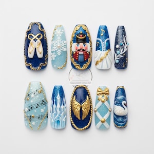 May include: A set of ten long, oval-shaped, decorated artificial nails. Designs include a ballerina's pointe shoes, a snowflake, a nutcracker, musical notes, a winter dress, a winter branch, musical notes, a castle, angel wings, a bow, and a swan.