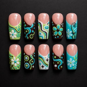 Puede incluir: Diez uñas artificiales con base rosa natural y diversos diseños coloridos. Los diseños incluyen patrones florales, remolinos y formas geométricas en verde, azul, marrón y blanco, sobre un fondo negro.