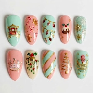 May include: A set of ten almond-shaped press-on nails featuring holiday designs. The nails are painted in pastel mint green and soft pink, decorated with gold accents, gingerbread men, candy canes, Christmas trees, crowns, and snowflakes.