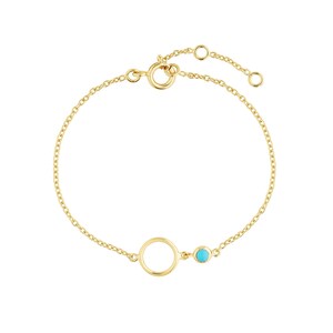 Pode incluir: Uma delicada pulseira dourada com um pequeno círculo aberto e uma pedra de cor turquesa. A pulseira tem um design de corrente com um fecho ajustável.