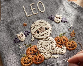 Gepersonaliseerd linnen schort voor kinderen met Halloween-thema, handgeborduurd en griezelig herfstbak-souvenir.